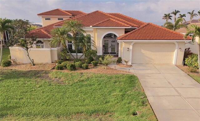 mediterranean / spanish house with french doors and a front lawn