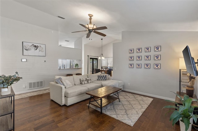 living room with ceiling fan, dark hardwood / wood-style floors, and vaulted ceiling