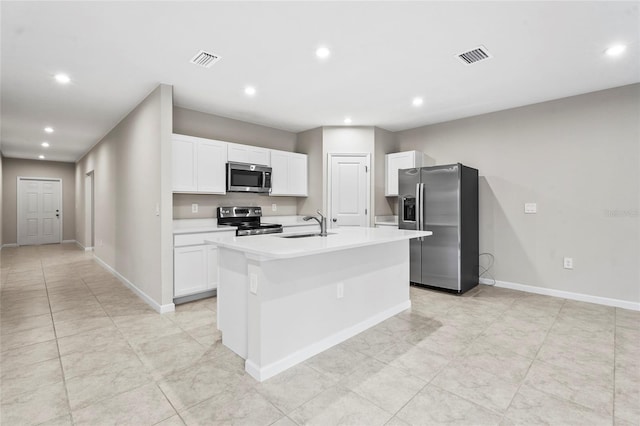 kitchen featuring white cabinetry, sink, stainless steel appliances, and a center island with sink