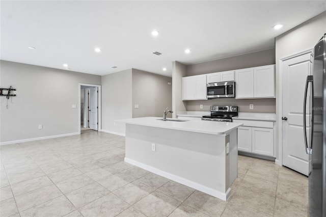 kitchen featuring appliances with stainless steel finishes, a kitchen island with sink, sink, and white cabinets