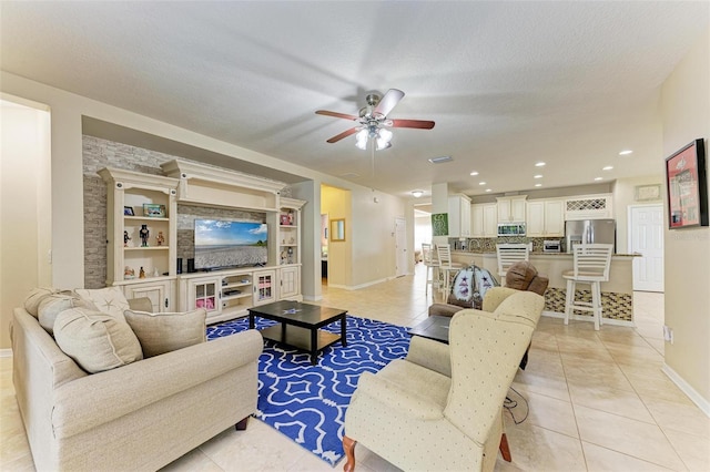 tiled living room featuring a textured ceiling and ceiling fan