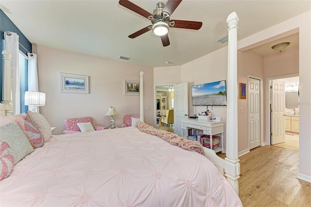 bedroom with ensuite bathroom, ceiling fan, and light hardwood / wood-style flooring