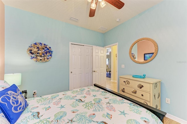 bedroom with baseboards, visible vents, a closet, and ceiling fan