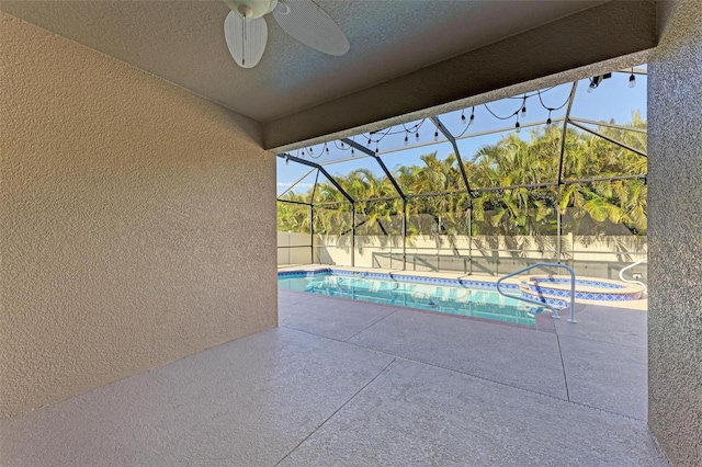 view of pool with a patio, ceiling fan, and glass enclosure