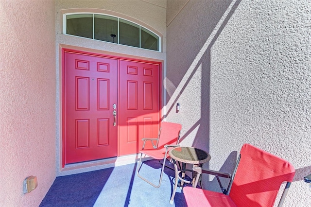 entrance to property featuring stucco siding