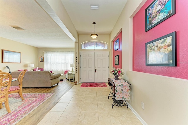 entrance foyer featuring light wood-style floors, visible vents, and baseboards