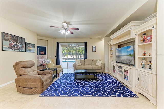 tiled living area featuring baseboards, a textured ceiling, a ceiling fan, and a sunroom