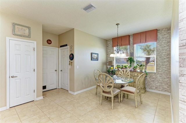 dining room with visible vents, a textured ceiling, an inviting chandelier, light tile patterned floors, and baseboards