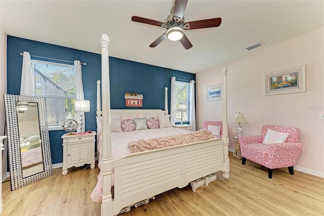 bedroom featuring visible vents, baseboards, wood finished floors, and a ceiling fan