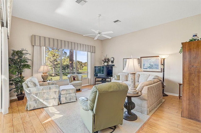 living room with ceiling fan and light hardwood / wood-style flooring