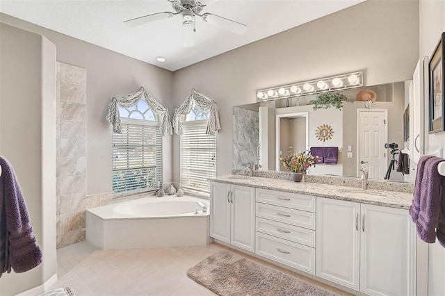 bathroom with tile patterned flooring, vanity, ceiling fan, and a bathtub