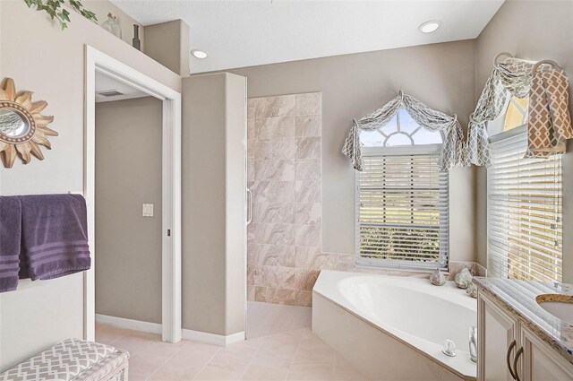 bathroom featuring tile patterned floors, a bath, and vanity