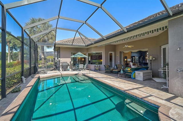 view of pool with ceiling fan, a lanai, and a patio