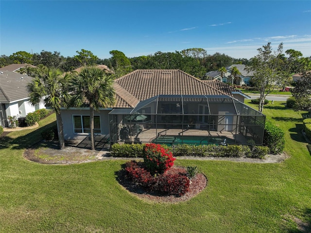 back of property with a patio, a yard, and glass enclosure