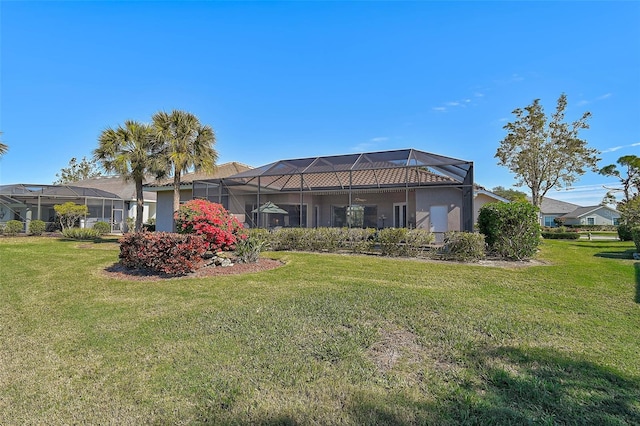 rear view of house featuring a yard and a lanai