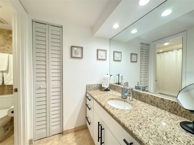 bathroom featuring vanity, tile patterned floors, and toilet