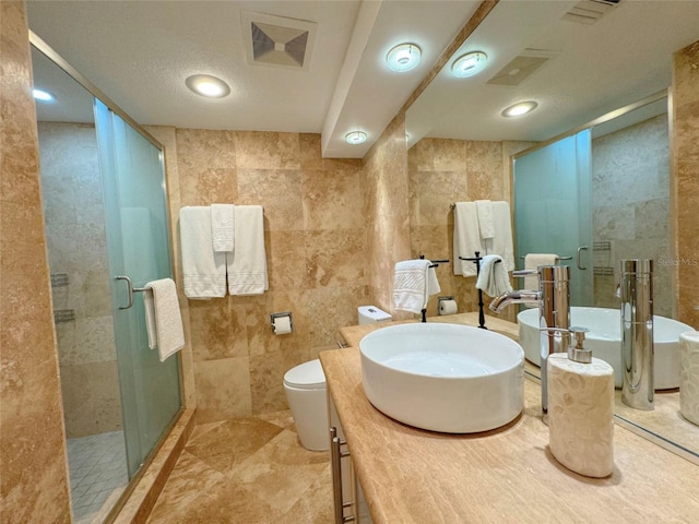 bathroom featuring tile walls, vanity, toilet, and walk in shower