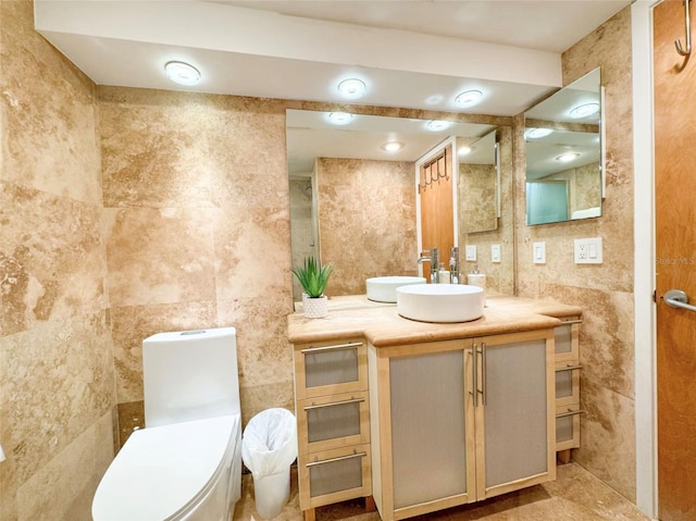 bathroom with vanity, tile walls, and toilet