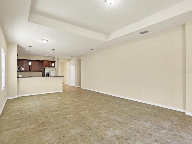 unfurnished living room with a tray ceiling