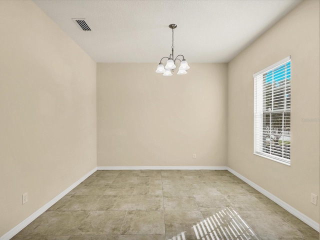spare room with an inviting chandelier