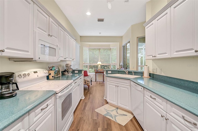 kitchen with white appliances, sink, and white cabinets