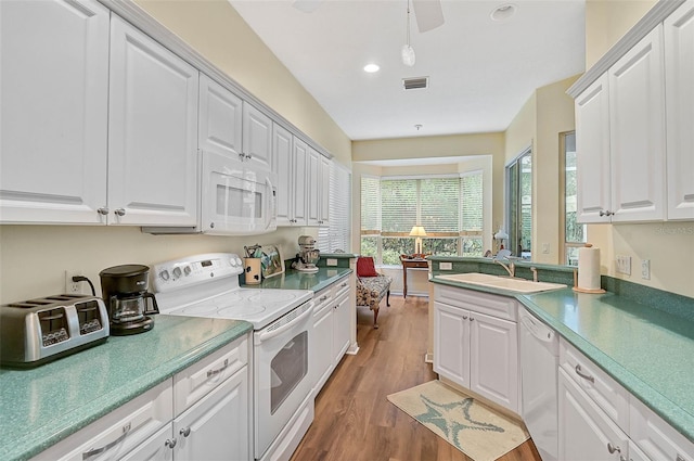 kitchen with white cabinetry, sink, white appliances, and dark hardwood / wood-style floors