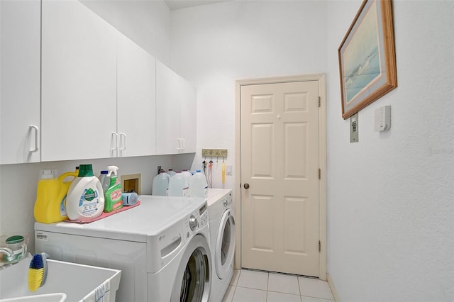 laundry area featuring cabinets, separate washer and dryer, and light tile patterned floors