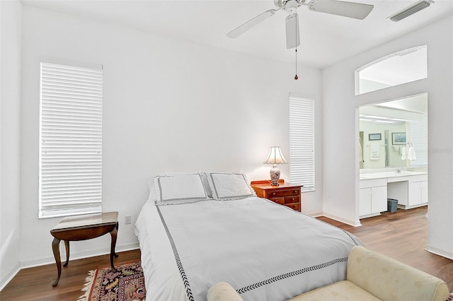 bedroom with ceiling fan, built in desk, and light wood-type flooring