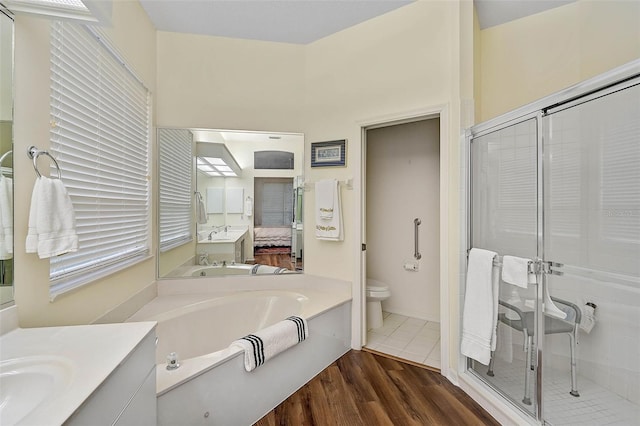 full bathroom featuring vanity, wood-type flooring, plus walk in shower, and toilet