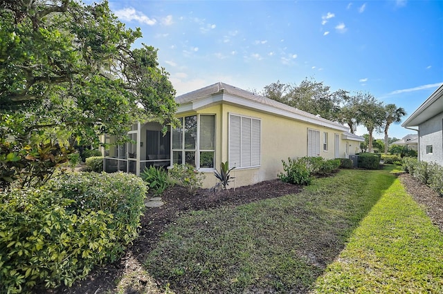 view of side of home featuring a yard and a sunroom