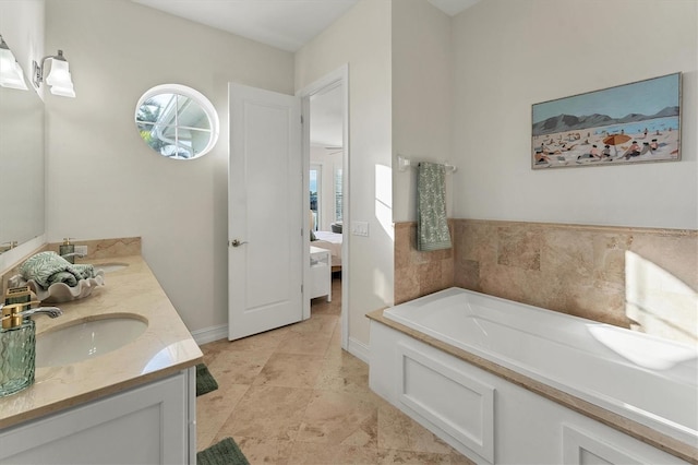 bathroom featuring vanity, a tub, and a healthy amount of sunlight