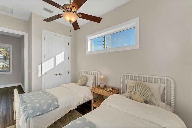 bedroom featuring ceiling fan, dark hardwood / wood-style flooring, and a closet