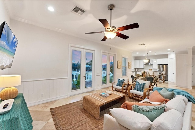 living room featuring ornamental molding, french doors, and ceiling fan