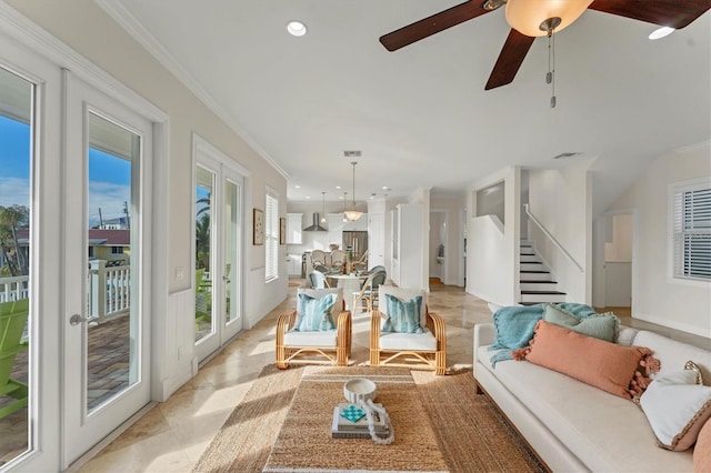 living room with ornamental molding and ceiling fan