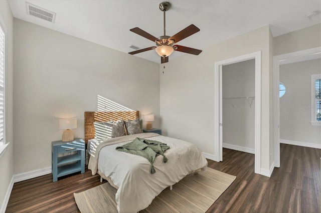 bedroom with dark hardwood / wood-style floors, ceiling fan, a spacious closet, and a closet