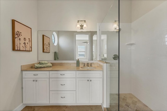 bathroom with tiled shower and vanity