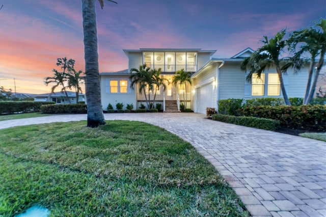 view of front of home with a garage and a lawn