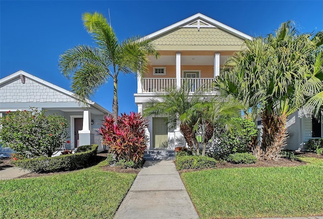 view of front of property with a balcony and a front lawn