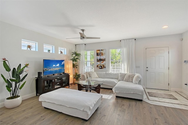 living room featuring light hardwood / wood-style floors and ceiling fan