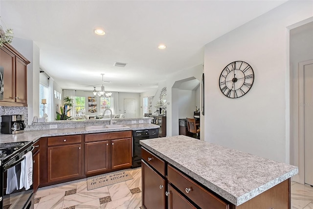 kitchen featuring sink, backsplash, a center island, a notable chandelier, and black appliances