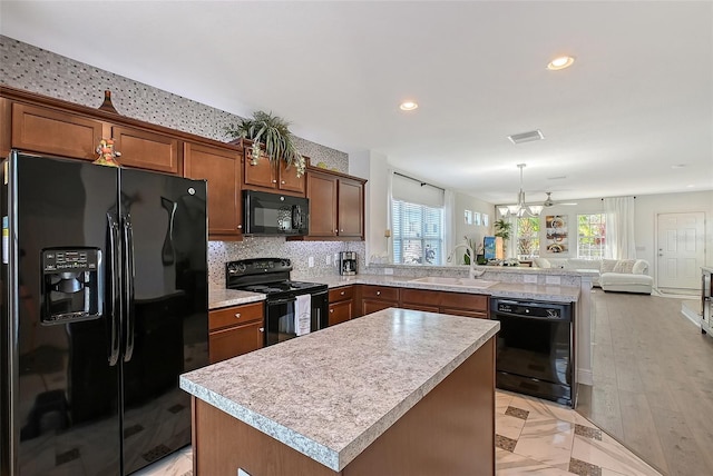 kitchen with sink, black appliances, kitchen peninsula, and a healthy amount of sunlight