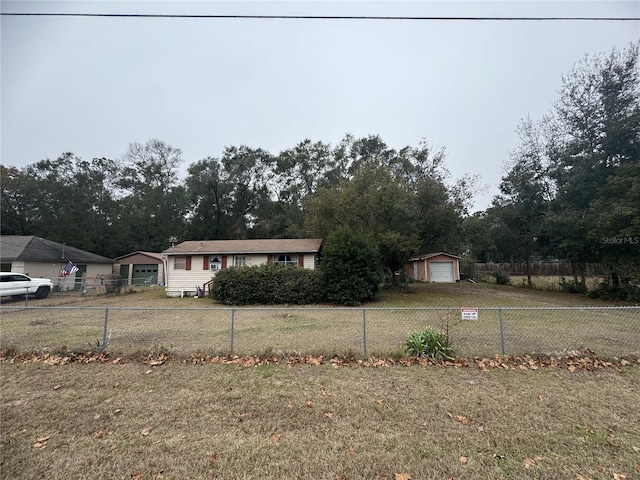 view of front of property featuring a garage, an outdoor structure, and a front lawn