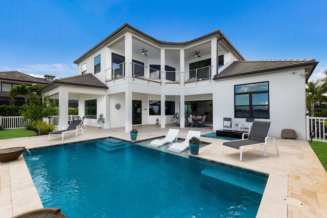 back of property with pool water feature, a patio, a balcony, and ceiling fan