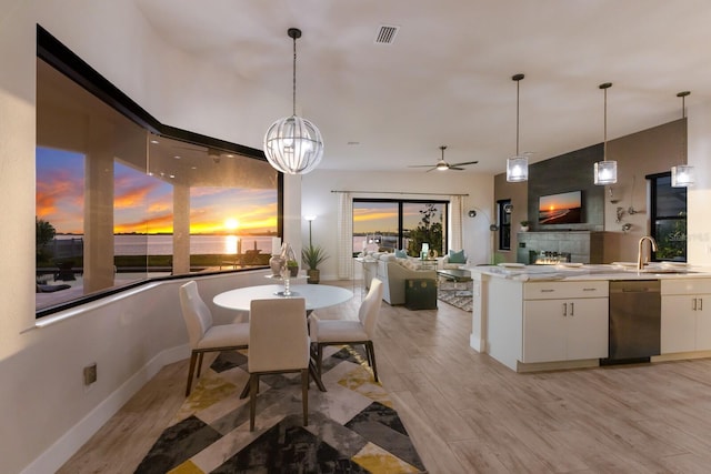 dining area with ceiling fan, sink, and light wood-type flooring