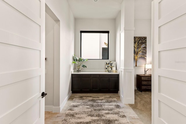 bathroom featuring vanity and ornate columns