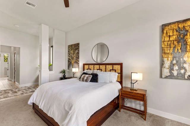 carpeted bedroom featuring ceiling fan, ensuite bathroom, and decorative columns