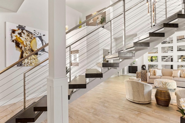 living room featuring a towering ceiling and hardwood / wood-style floors