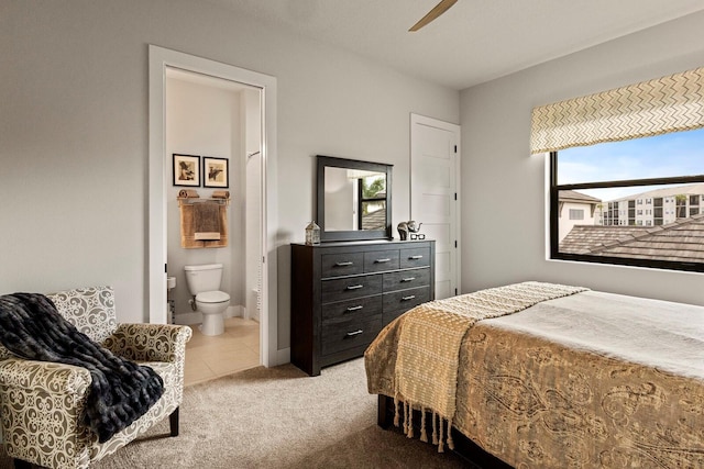 carpeted bedroom featuring ceiling fan and ensuite bath