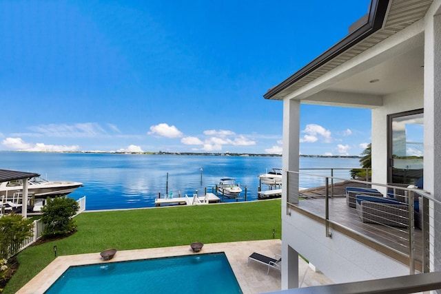 view of swimming pool with a water view, a lawn, and a boat dock