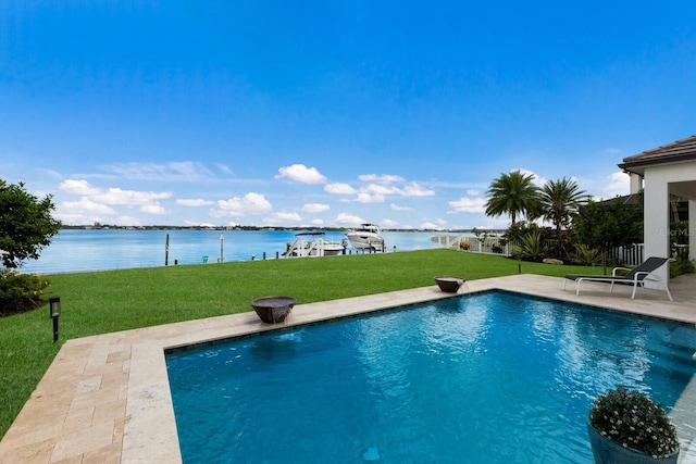 view of pool with a water view, a lawn, and a patio area